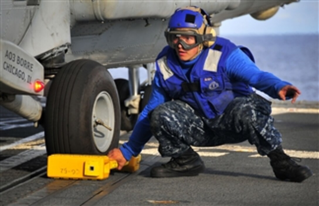 U.S. Navy Seaman Apprentice Anthony Orduna prepares to remove a chock from the landing gear of an SH-60F Seahawk helicopter during flight operations aboard the guided-missile cruiser USS Bunker Hill (CG 52) in the Pacific Ocean on April 6, 2010.  The Bunker Hill is supporting Southern Seas 2010, a U.S. Southern Command-directed operation.  