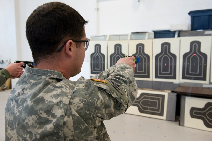 Idaho Army National Guard Sgt. Andrew Tuttle fires a taser at a target during familiarization training on Gowen Field, Boise Idaho, February 10, 2010. The QRF is a joint force, volunteer, team that responds to nonthreatening and threatening disasters that may require the use of a taser which gives them the opportunity to defend themselves and others without causing any long term injury.