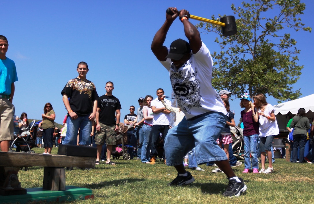 Gunnery Sgt. Burnett C. Sheppard, operations chief, 1st Marine Expeditionary Force, slams a mallet to win a prize during the Lincoln Military Housing annual Spring Carnival at Lake O'Neill, April 10. The event was an underwater-themed carnival that spanned the shores of the base's largest lake, and provided military families with everything from carnival rides and games to face painting and funnel cakes.