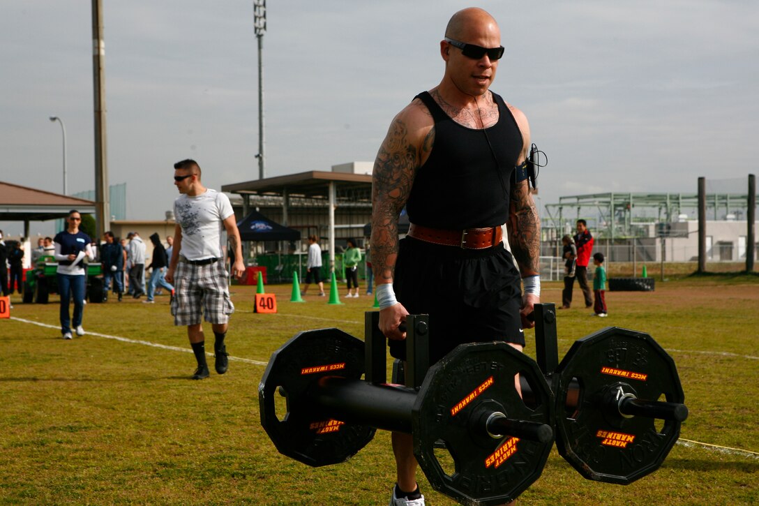 Adrian Figueroa powers through the farmer's walk during the 4th annual Strongman Competition held at Penny Lake fields here April 10. Figueroa managed to haul the 248 pounds 63.3 yards to take first place in the event for the 160 pounds and under male weight class.