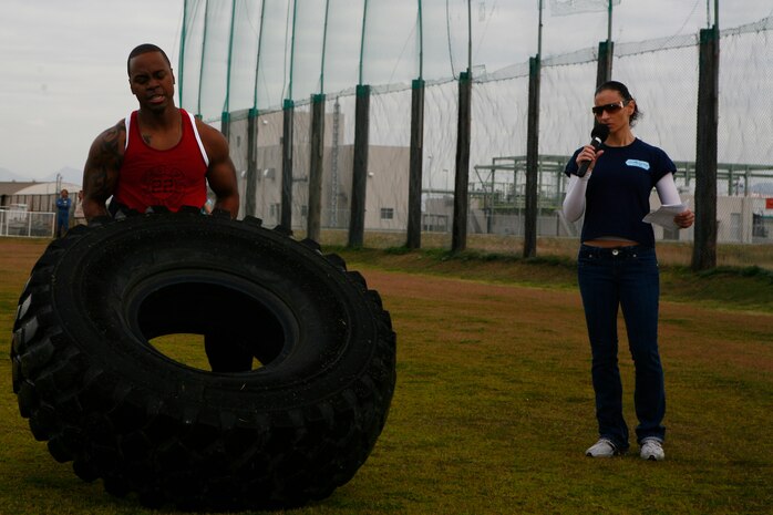 Jerome Taylor struggles to flip a 7-ton truck tire, weighing approximately 550 pounds, during the tire flip event of the 4th annual Strongman Competition held at Penny Lake fields here April 10. Taylor managed 27 tire flips and took third place in the male 161-190-pound weight class.