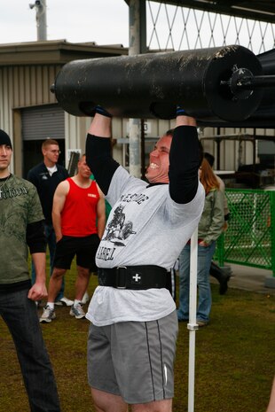 O.J. Weiss strains to get one more press of the 153-pound log during the steel log clean and press event as part of the 4th annual Strongman Competition held at Penny Lake fields here April 10. Weiss managed to press the log 20 times to take first place in the event for the male 191-pound and up weight class.