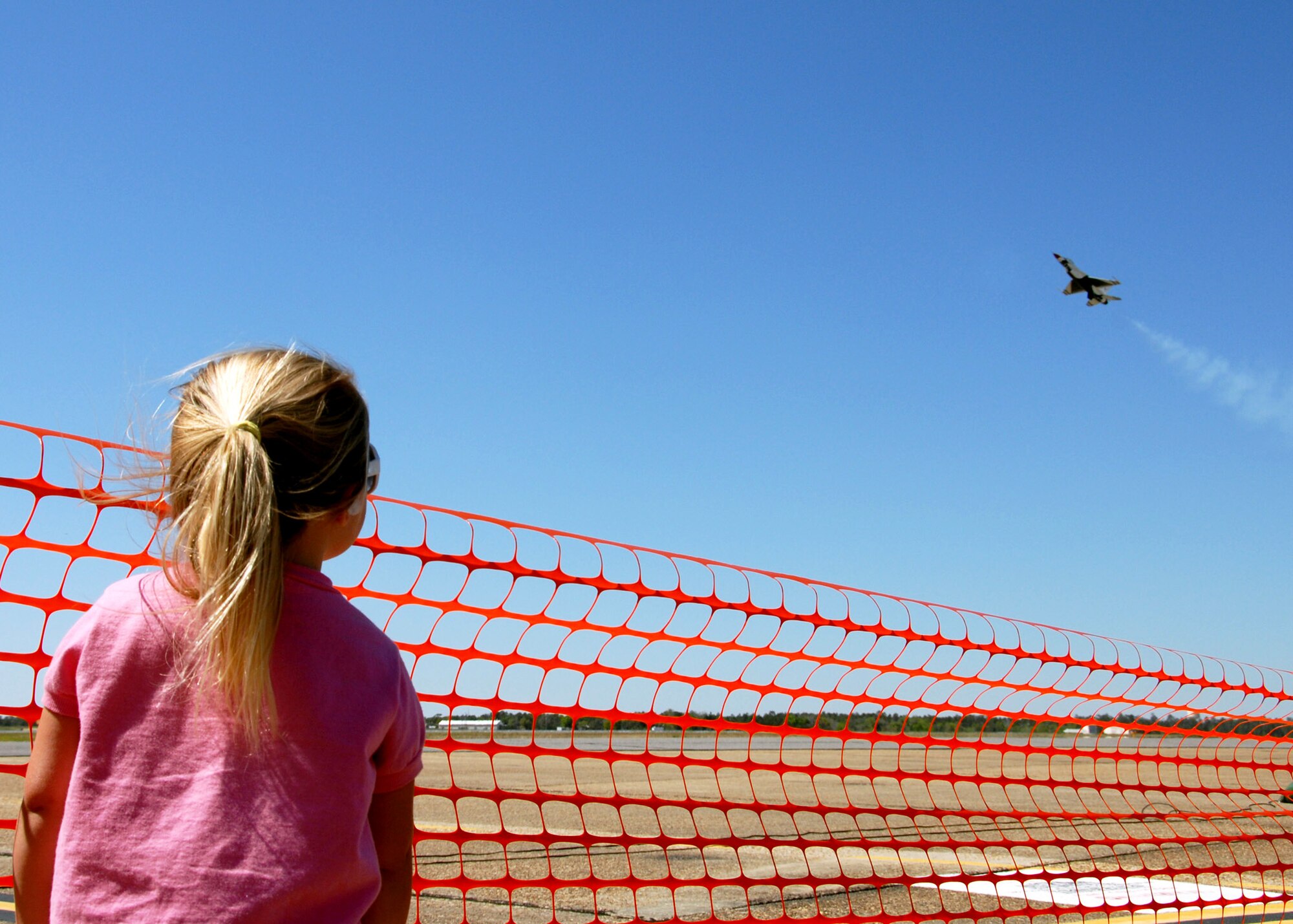 EGLIN AIR FORCE BASE, Fla. -- Three-year-old Gabbrielle Jorgensen watches a Thunderbird F-16 during a practice show April 9 here.  The weekend airshow drew more than 70,000 people each day. The T-birds headlined the show. (U.S. Air Force photo/Samuel King Jr.)
