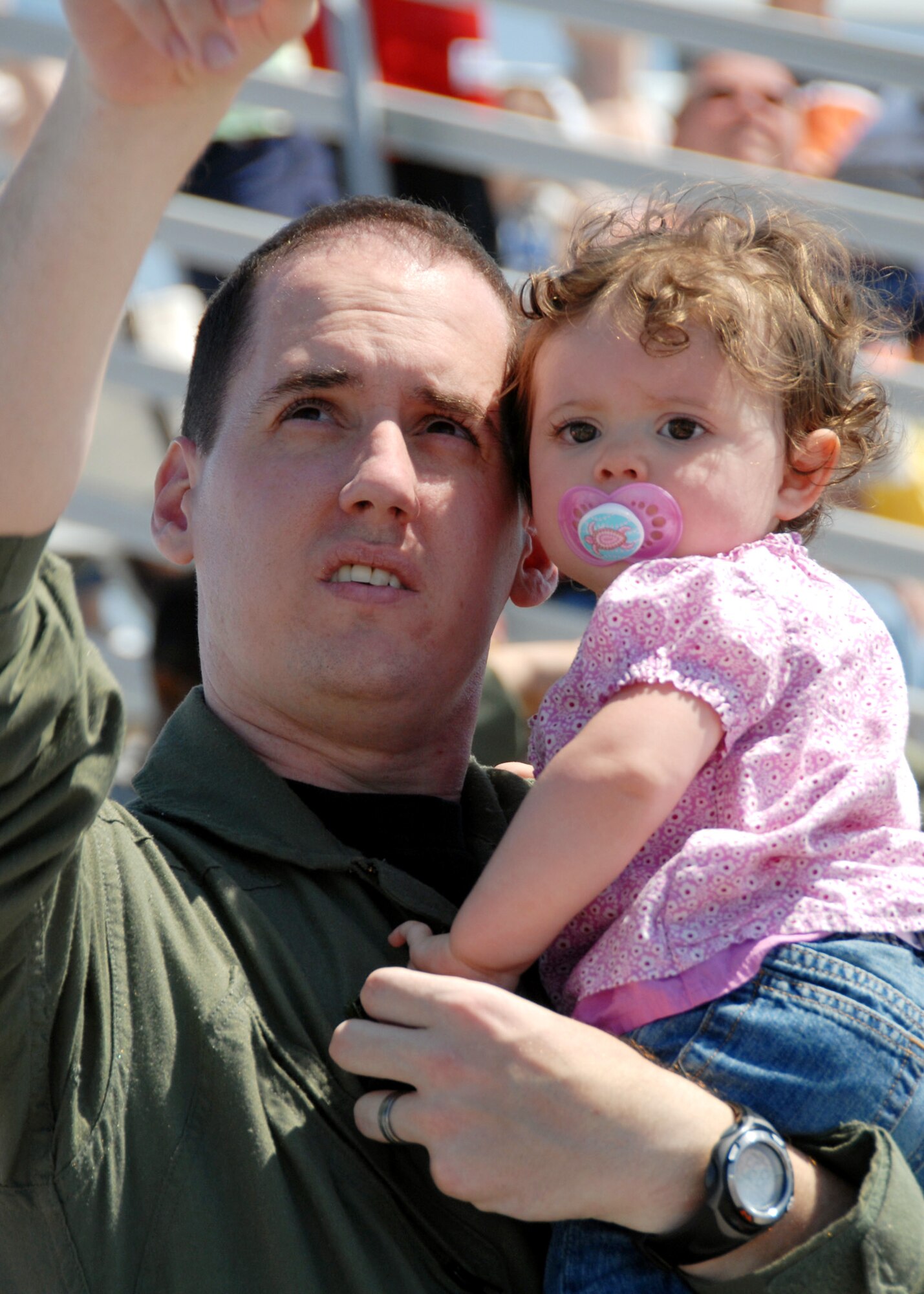 EGLIN AIR FORCE BASE, Fla. -- Capt. Steven Anslow, 9th Special Operations Squadron, points out the approaching Thunderbird F-16s to 1-year-old daughter Riley April 9 here. The weekend airshow drew more than 70,000 people each day.  The T-birds headlined the show.  (U.S. Air Force photo/Samuel King Jr.)