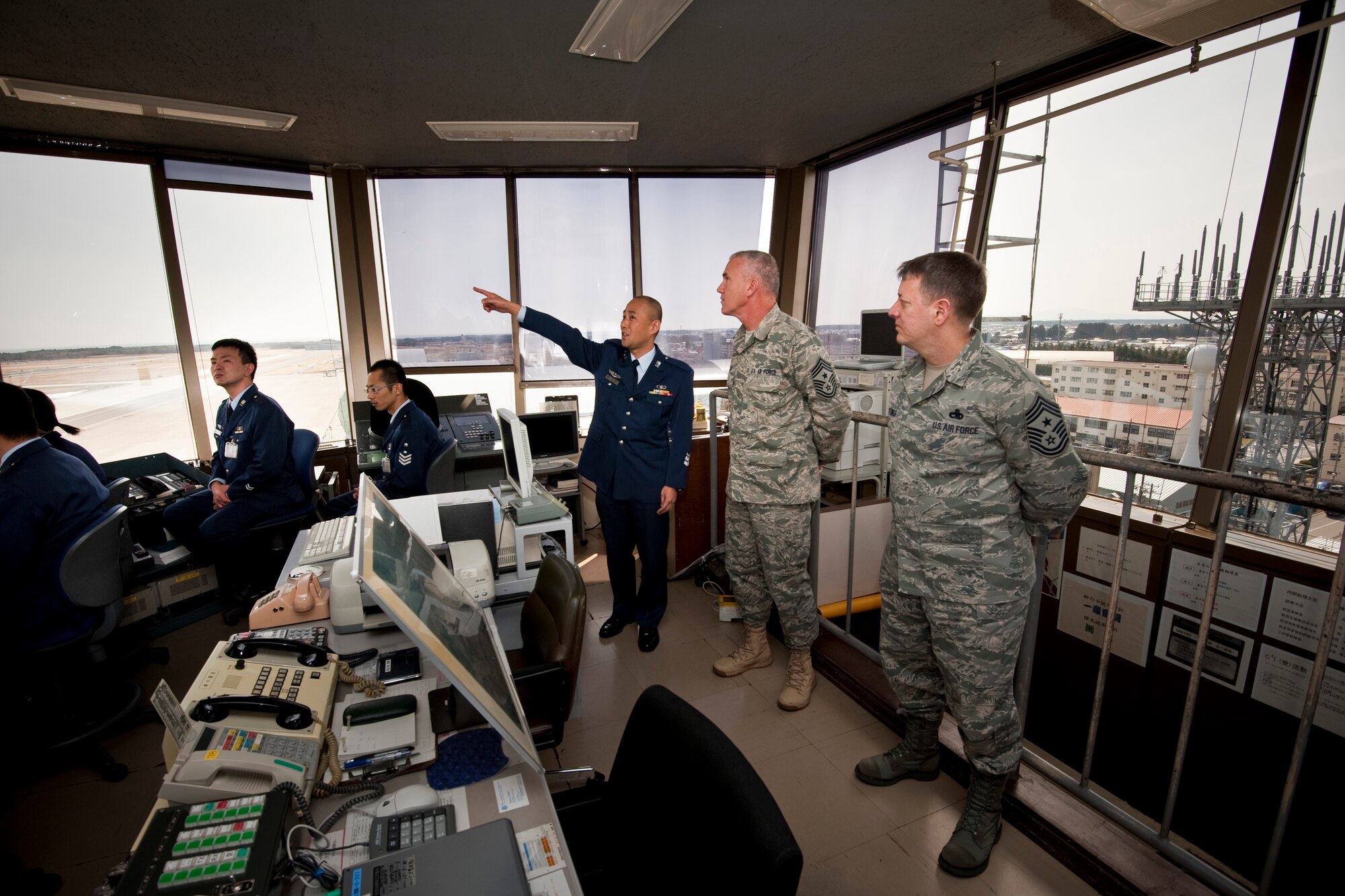 MISAWA AIR BASE, Japan -- Japan Air Self-Defense Force Chief Master Sgt. Minoru Inadomi gives Chief Master Sgt. Brooke McLean, Pacific Air Forces command chief master sergeant, a tour of Misawa's air traffic control tower April 9. Chief Inadomi showed Chief McLean the layout of the base from their vantage point. (U.S. Air Force photo/Staff Sgt. Samuel Morse)
