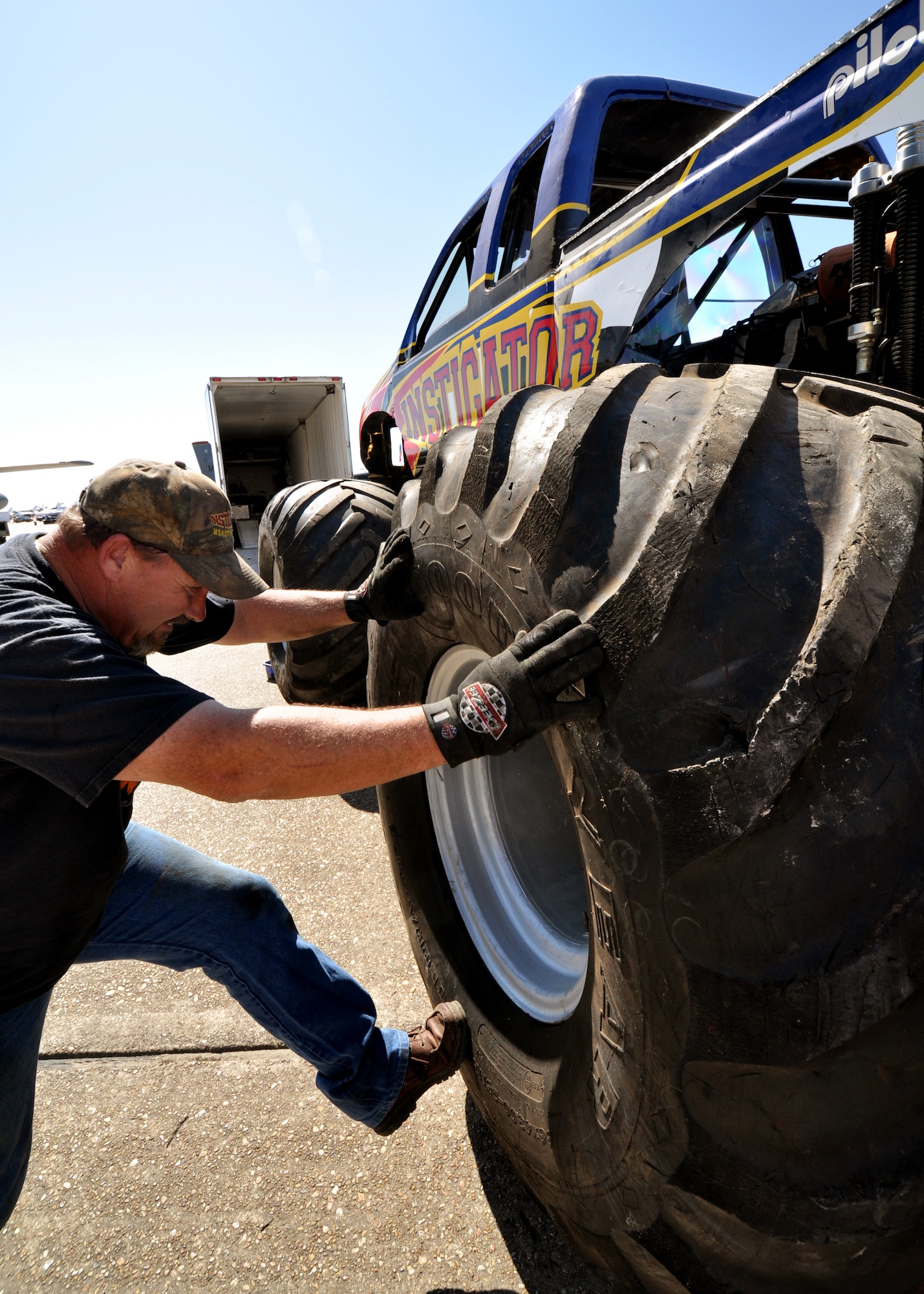 Lionel Easler kicks the "monster" tires into place on his truck "The Instigator," April 9 in preparation for the weekend airshow at Eglin Air Force Base, Fla.  The truck was on display with the Air Force Reserve recruiting booth.  Mr. Easler has been driving monster trucks for five years and competes in about 35 truck shows a year.  This was the first airshow however for the Florida native.  (U.S. Air Force photo/Tech. Sgt. Samuel King Jr.)