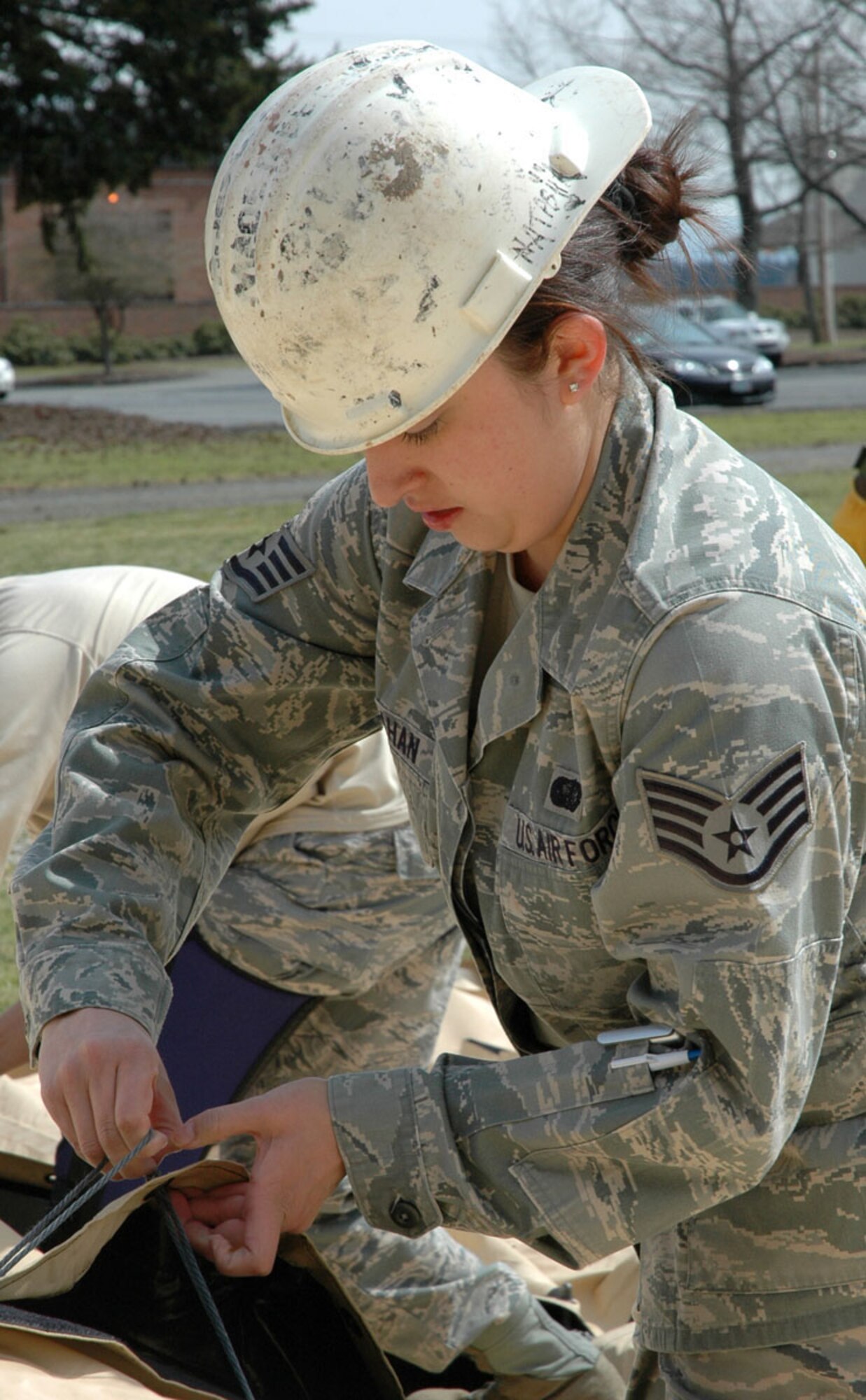 JOINT BASE LEWIS-MCCHORD, Wash. -- Staff Sgt. Tesla Hanrahan, a Reservist with the 446th Services Flight here, ties together the support poles for a single pallet expeditionary kitchen, or S.P.E.K., during a training exercise April 10.  A S.P.E.K. has the capability to serve hundreds of meals to hungry troops in austere deployed environments. (U.S. Air Force photo/Staff Sgt. Grant Saylor)