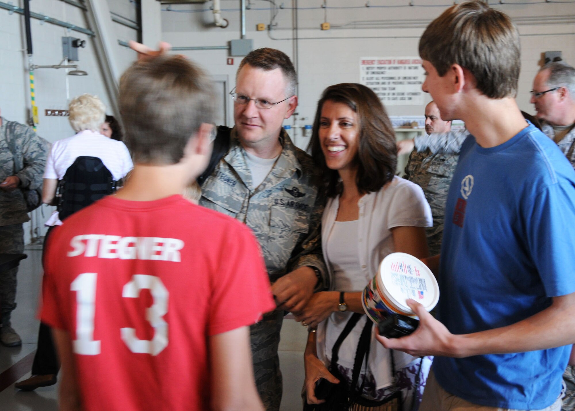 Air Force Reserve Lt. Col. Christopher Stegner from Duke Field's 711th Special Operations Squadron, is welcomed home by his sons Evan (left) and Andrew and wife Jennifer inside a hangar at Hurlburt Field April 6. Known as Operation Homecoming, the event reunited returning Duke Field and Hurlburt warfighters with family, fellow Airmen and local civic leaders following lengthy deployments in support of operations in Southwest Asia. (U.S. Air Force photo/Adam Duckworth)