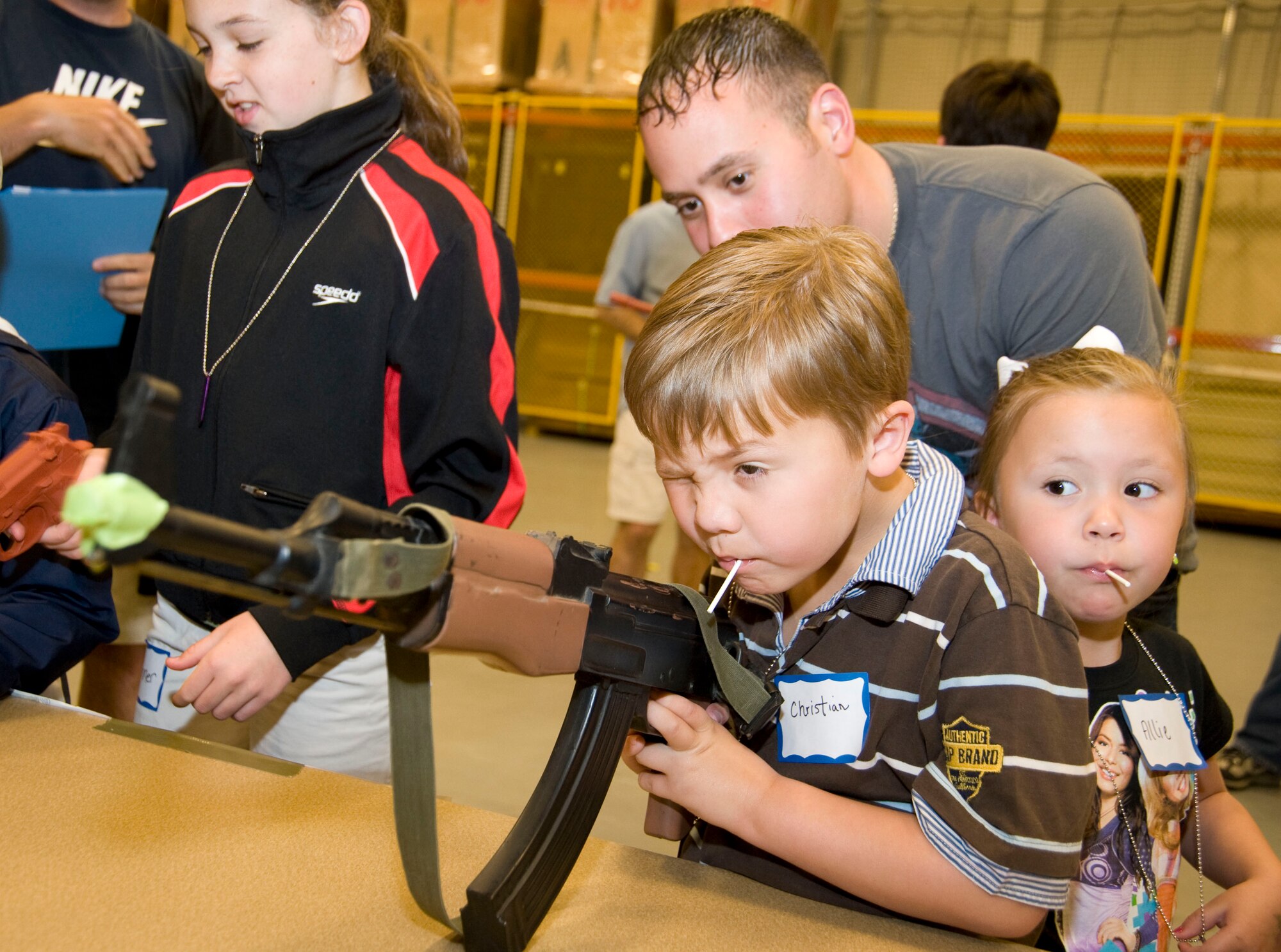 Christian Cruz lines up his sights on a mock AK-47 assault rifle at the Combat Arms Training and Maintenance/Weapons Display station during Herc Day. Christian and his sister, Allie, are the children of Tech. Sgts. Alex and Carrie Cruz, 41st Aerial Port Squadron aerial porters.