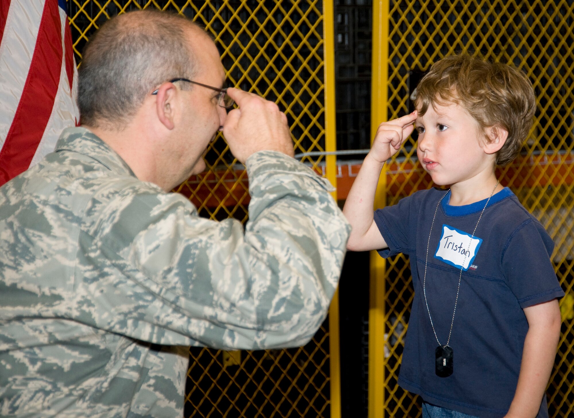 Tristan, son of Senior Airman Henry Hainsworth, learns the fine art of "shake, take and salute" during Herc Day. Brig. Gen. James Muscatell, 403rd Wing commander, presented each of the young participants with a certificate and coin during the event. Airman Hainsworth is a 41st Aerial Port Squadron supply journeyman.