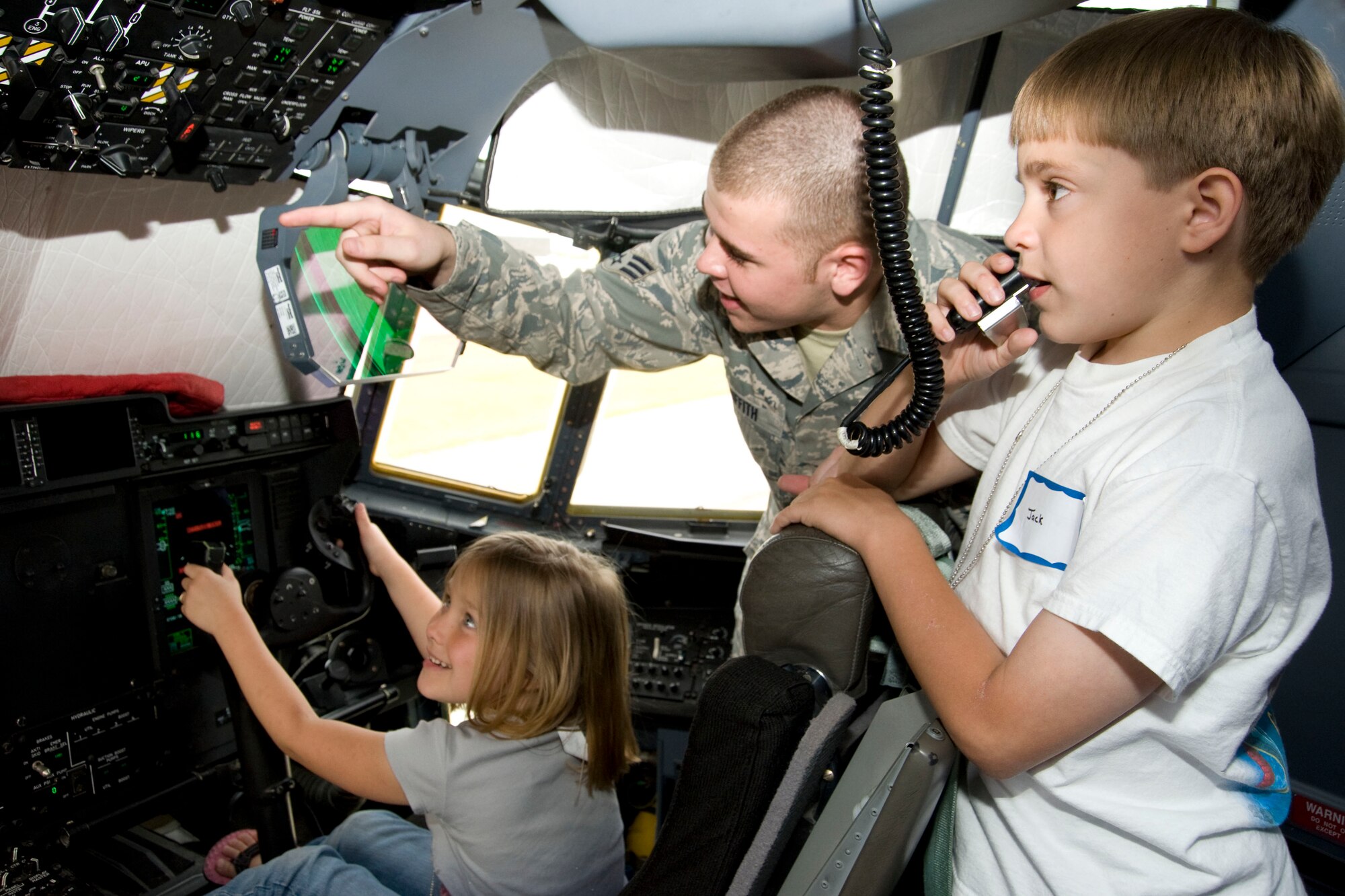 Senior Airman Joshua Griffith, 403rd Aircraft Maintenance Squadron crew chief, explains some of the cockpit controls to Emma Young while Jack Dufrene pretends to make announcements using part of the C-130J-30 cockpit's communicaions system. During Herc Day, familes of 403rd Wing reservists toured two static displays, an 815th Airlift Squadron C-130J-30 and a 53rd Weather Reconnaissance Squadron WC-130J aircraft. Emma is the daughter of Capt. Bobbie Young, 403rd Services Flight, and Jack is the son of Master Sgt. John Dufrene, 403rd Maintenance Operations Flight maintenance scheduler.