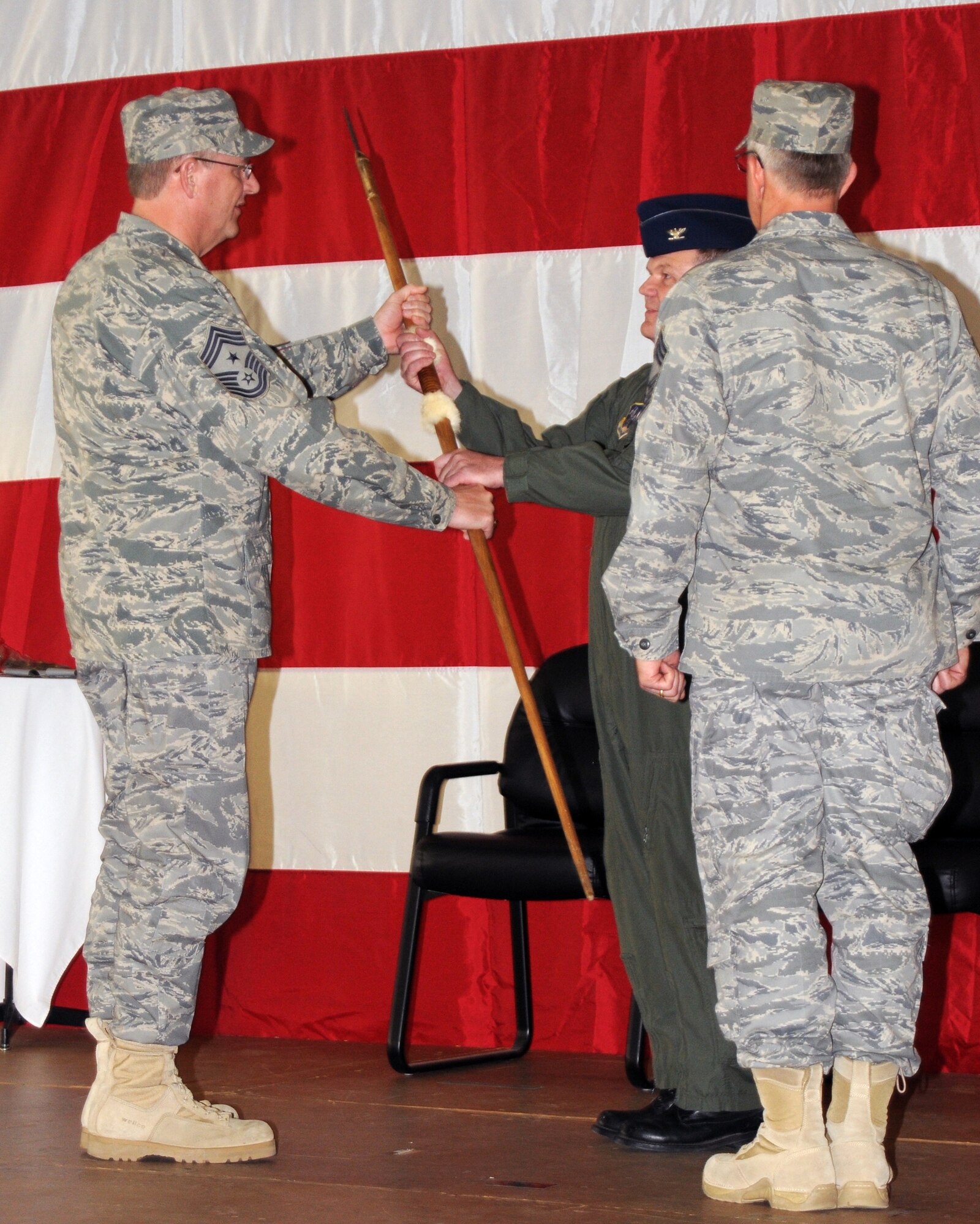 Command Chief  Master Sergeant Don Keuhl passes the ceremonial spear to Col. Brian Miller.