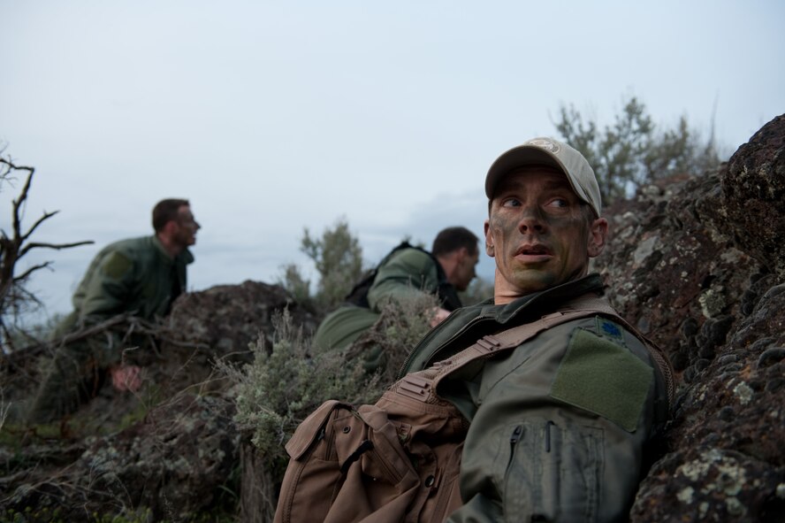 Lt. Col. Shannon Smith, 124th Fighter Wing, hides from opposing forces during Survival, Evasion, Resistance, and Escape refresher training at the Orchard Training Area near Boise, Idaho, April 10. Pilots from the 124th FW conducted refresher training in land navigation and evasion techniques with help from the 124th Life Support section and active duty Airmen from the 366th Operations Support Squadron SERE flight based at nearby Mountain Home Air Force Base. 