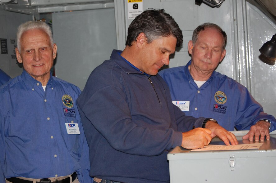 Jerry Johnson (center), owner of Sports Source Orthopedics, signs an Employer Support of the Guard and Reserve Statement of Support aboard a KC-135R Stratotanker during a recent bosslift hosted by the 916th Air Refueling Wing. (USAF photo by Maj. Shannon Mann, 916ARW/PA)