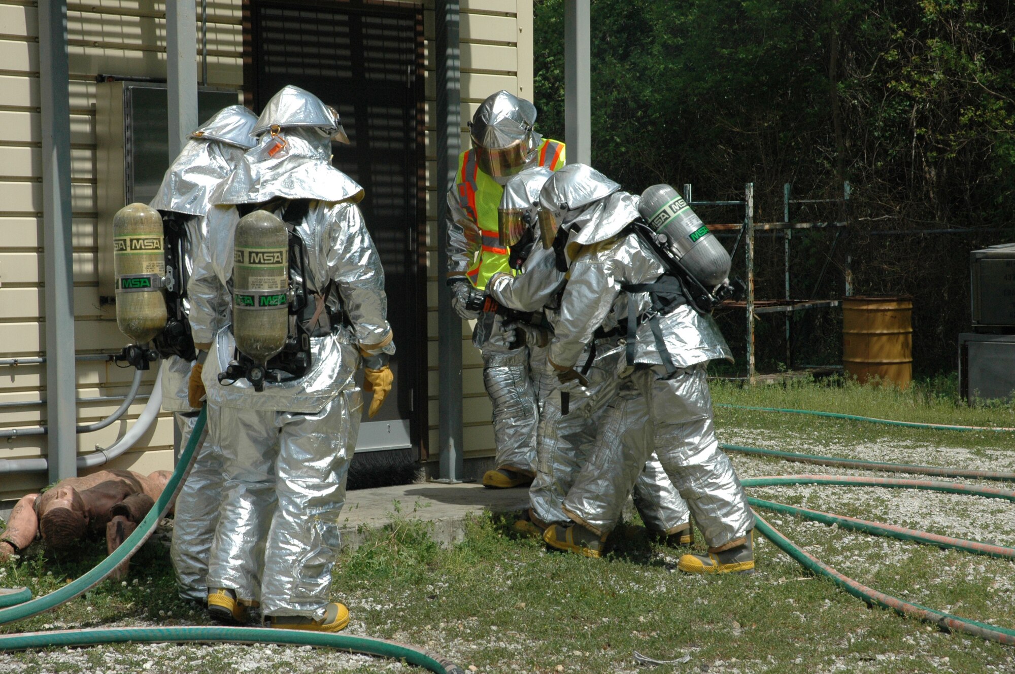 Seventeen firefighters assigned to 315th Civil Engineering Flight donned their aircraft rescue suits for mandatory daytime live fire training Saturday, April 10 at Charleston Air Force Base, S.C. Sweeping through the ‘burn building’ in teams of four, the firefighters were required to extinguish a simulated kitchen fire burning up to 700 degrees before backing out of the structure. Each run-through also allowed the firefighters additional training on the fire rescue truck by repacking the hose and returning the truck to a ‘serviceable’ condition. (U.S. Air Force photo by Senior Airman Dani Shea / Released)
