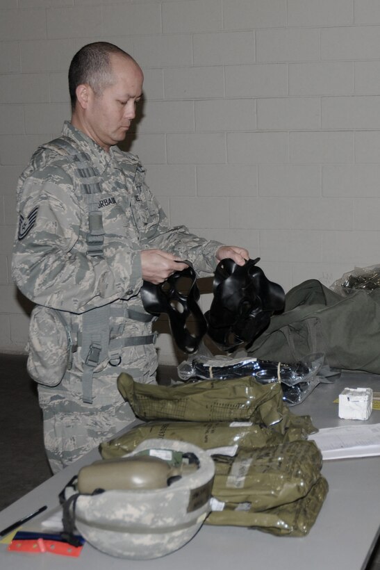 After verifying the JSList items in his mobility bag, Technical Sgt. John Surbaugh begins to pack the bag for travel during an Operational Readiness Exercise held in the Supply building of the 132d Fighter Wing in Des Moines, Iowa, on April 10, 2010.  This particular mobility bag is also called the C1 bag; it contains items such as the gas mask second skins (Surbaugh is holding these), and other various Chemical Protective Equipment items.  (US Air Force photo/Staff Sgt. Linda E. Kephart)(Released)