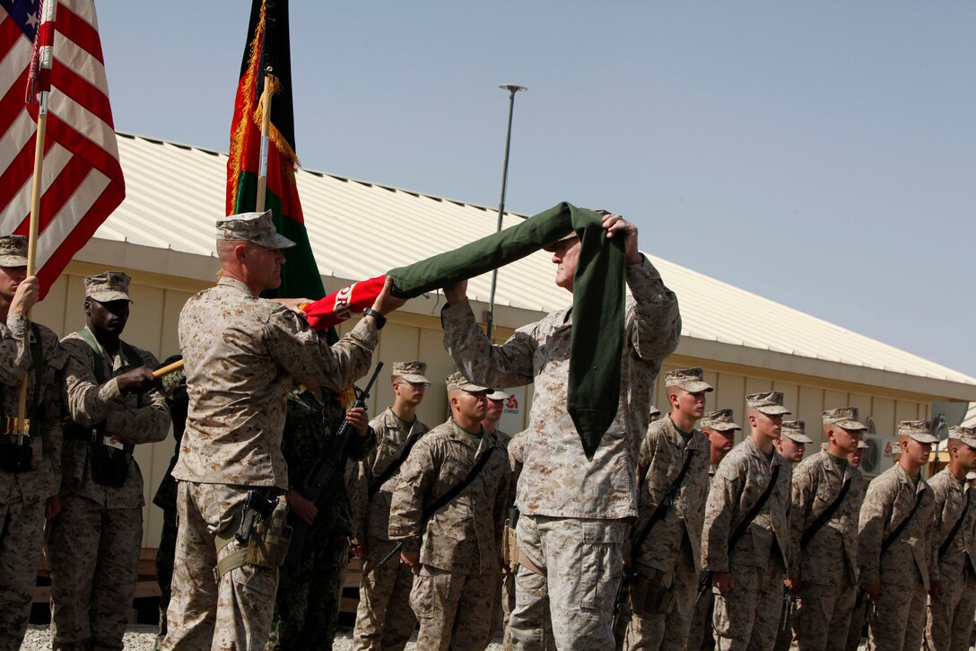 Maj. Gen. Richard P. Mills, commanding general for I Marine Expeditionary Force (FWD), and Sgt. Maj. Michael P. Barrett, sergeant major for I MEF (FWD), uncase the unit’s colors during a transfer of authority ceremony at Camp Leatherneck, Helmand province, Afghanistan, Monday.