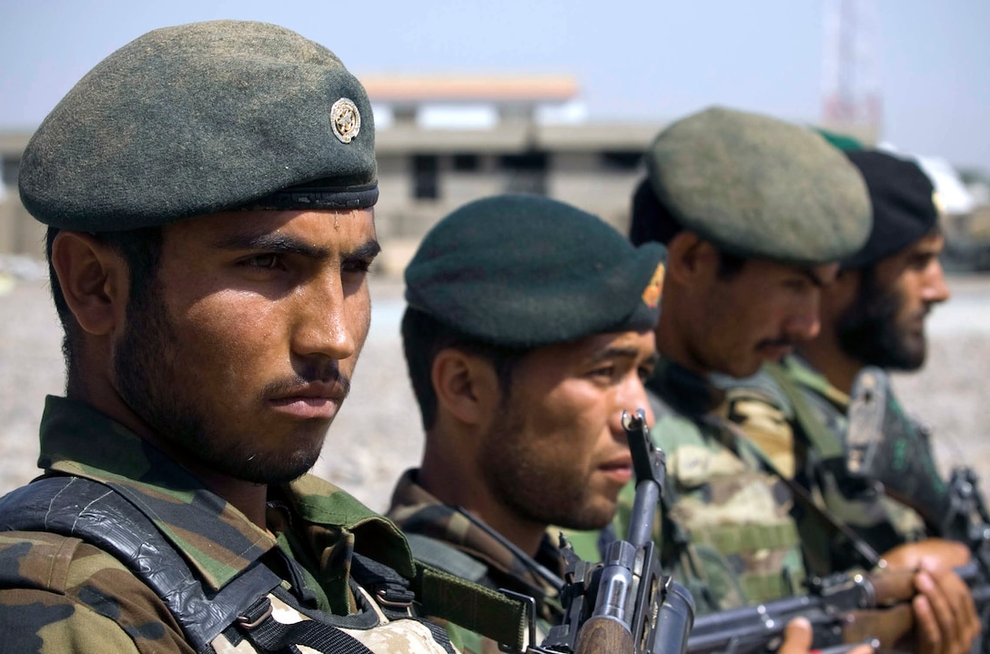 Afghan National Army soldiers stand in formation as Col. Ali Ahmad, an ANA cultural and religious advisor, speaks to a crowd of people at Nawa’s first-ever ANA recruiting and information event April 12.  More than 60 people attended the event at Patrol Base Jaker to hear about the benefits of military service.