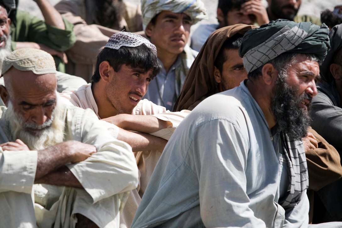 Men from Nawa listen to Col. Ali Ahmad, an Afghan National Army cultural and religious advisor, speak during Nawa’s first-ever ANA recruiting and information event April 12.  More than 60 people attended the event at Patrol Base Jaker to hear about the benefits of military service.