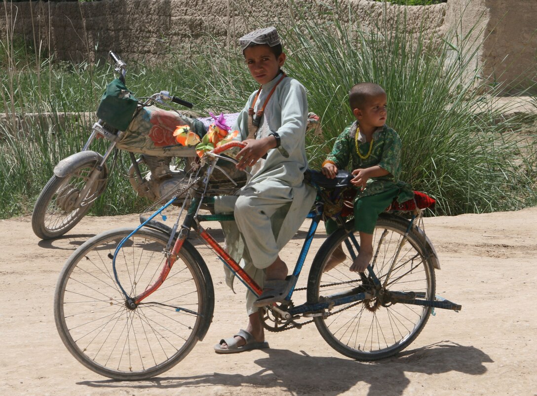 Two Afghan boys ride their bike through the bazaar in Marjah Afghanistan, April 13. Marines and Afghan National Army soldiers with 1st  Battalion, 6thMarine Regiment are taking part in the Marjah Accelerated Agricultural Transition program, which is a project aimed at facilitating the transition from illicit to licit crops.