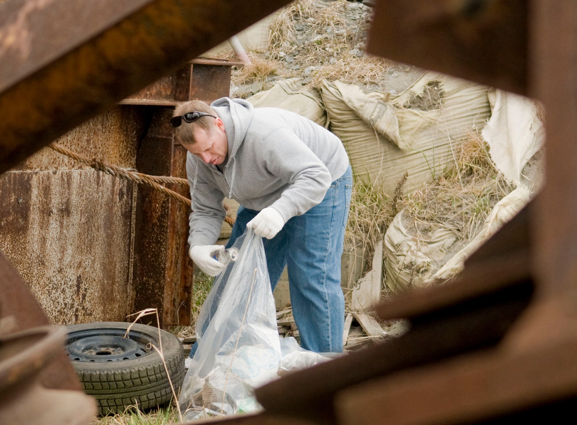MISAWA AIR BASE, Japan – Master Sgt. Brian Spalding, 35th Fighter Wing Flight Safety office NCO, loads trash into a plastic bag during the 13th  Annual Misawa Port and Beach cleanup, April 10. The annual event cleared the port and beach of debris and large items washed ashore onto the rocks and beach title wall barriers. (U.S. Air Force photo/Senior Airman Jessica Lockoski)