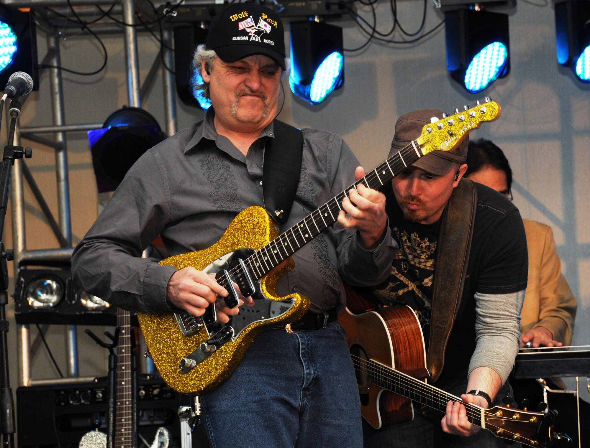 Lead guitarist John Delaney Jackson (left) and acoustic guitarist Cary Stone, members of country singer Mark Chesnut's band, perform at Kunsan Air Base, South Korea April 10, 2010. The performance was the last of three shows the band played in South Korea as part of a Stars for Stripes tour. (U.S. Air Force photo by Senior Airman Anna-Marie Wyant)