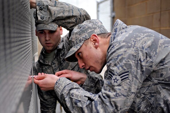 ELLSWORTH AIR FORCE BASE, S.D. -- (Right) Senior Airmen Brandon Bolden and Christopher Harris, 28th Civil Engineer Squadron heating, ventilation and air conditioning repair journeymen, replace vent coverings on an air conditioning unit after performing general maintenance, April 12. The 28th Civil Engineer Squadron provides the necessary assets and skilled personnel to prepare and sustain installations throughout the world during current deployment operations. (U.S. Air Force photo/Airman 1st Class Matthew Flynn)
