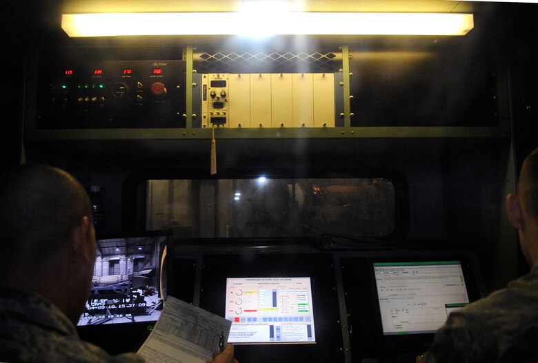 LANGLEY AIR FORCE BASE, Va. - Staff Sgt Cesar Delgadillo, 1st Component Maintenance Squadron aerospace propulsion craftsman, and Airman 1st Class Mathew Santianna, 1 CMS aerospace propulsion journeyman,  prepare to test a Pratt and Whitney F119-PW-100 engine at the hush house April 9.  The crew can control the engine remotely from a specially-designed mobile control center, called a “run cab.” (U.S. Air Force photo/Airman 1st Class Gul Crockett)
