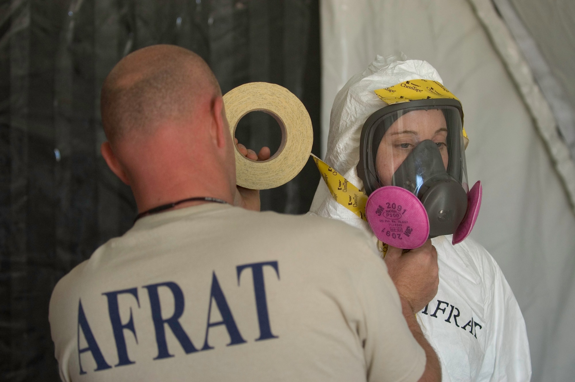 The USAFSAM Air Force Radiation Assessment Team (AFRAT) relies on training and technology to keep responding DoD personnel safe during a radiologic or nuclear emergency. Here, MSgt Ty Richards adjusts TSgt Jalayne Powers’ respirator during a training exercise. (USAF Photo by Steven Thurow)