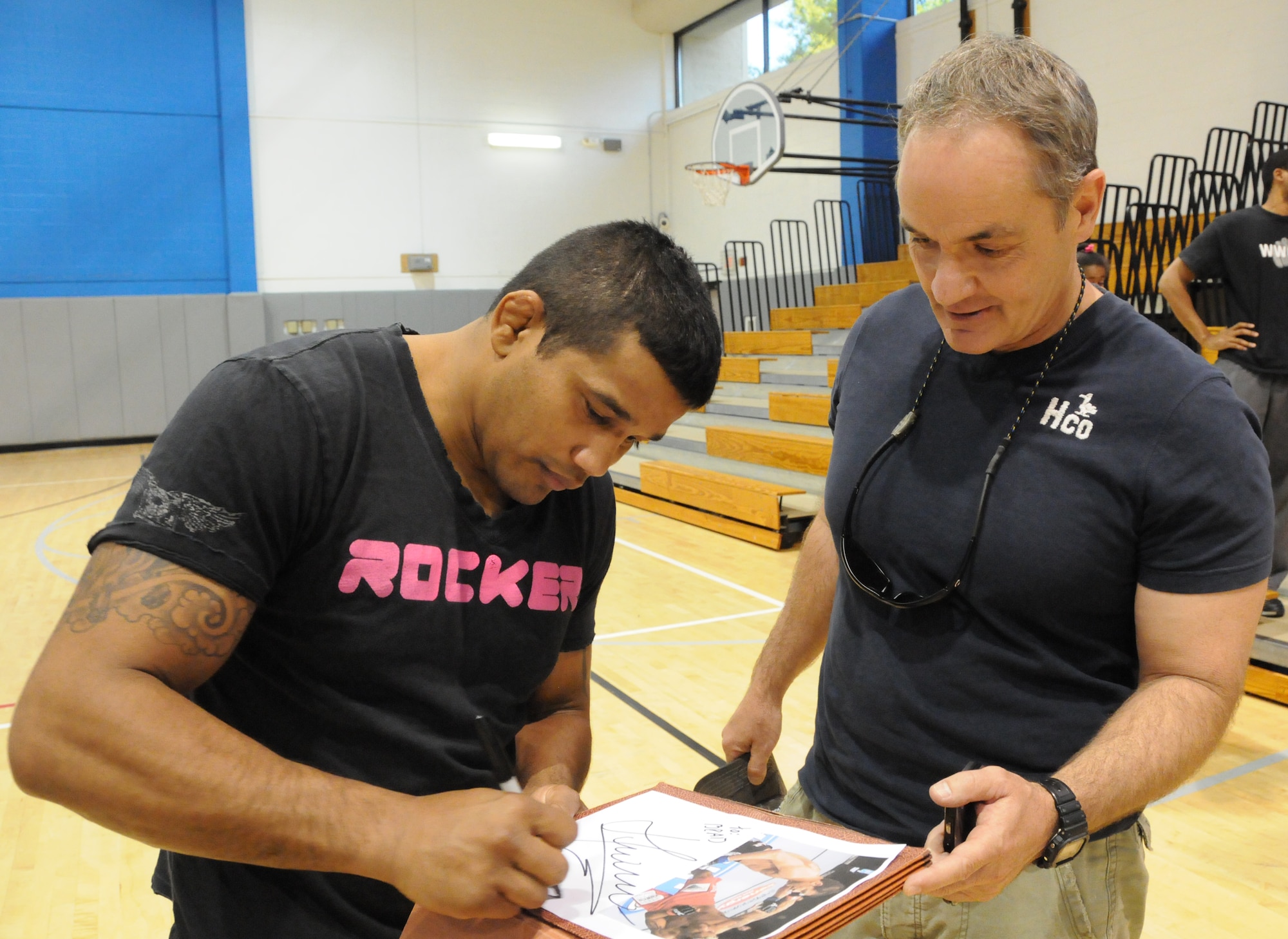 Hermes Franca, a Brazilian Jiu-Jitsu black belt champion, left, autographs a photo for Brad Hawkins, 505th Combat Training Squadron, at the Aderholt Fitness Center at Hurlburt Field April 9. Mr. Franca visited with fans on base before giving a seminar at a new training center in Fort Walton Beach, Fla. (U.S. Air Force photo by Reuben Garcia) 