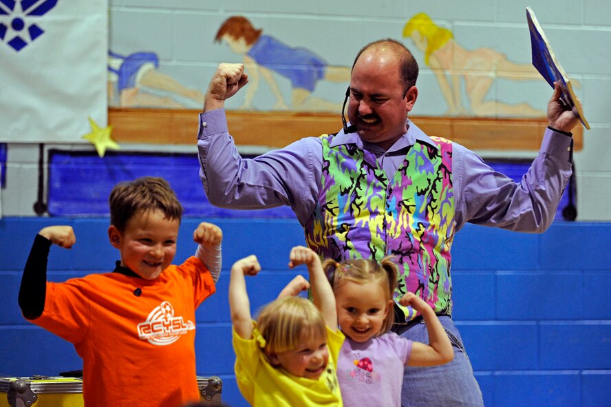 ELLSWORTH AIR FORCE BASE, S.D. -- Keith Raymond and children of service members flex their muscles prior to performing a magic trick, April 10. Mr. Raymond performed a magic show at the Youth Center to celebrate April as Month of the Military Child. (U.S. Air Force photo/Airman 1st Class Matthew Flynn)