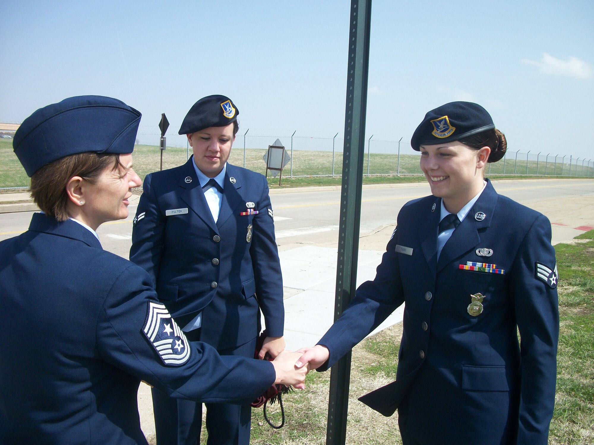OFFUTT AIR FORCE BASE, Neb. -- Chief Master Sgt. Lisa A. Sirois, 55th Wing command chief, thanks Senior Airman Danielle Tibbs, (right), and Airman 1st Class Fallon Fulton, (left), both with the 55th Security Forces Squadron, after they unveiled the Tull Road sign at the intersection of Tull Road and SAC Boulevard during the Tull Road dedication ceremony here April 6. The road was named in honor of retired Lt. Col. Harrison "Harry" Tull, a Tuskegee Airman during World War II and a former 55th Wing officer who recently passed away. Colonel Tull served more than 27 years in the Air Force including combat tours in the Korean and Vietnam Wars. U.S. Air Force Courtesy Photo
