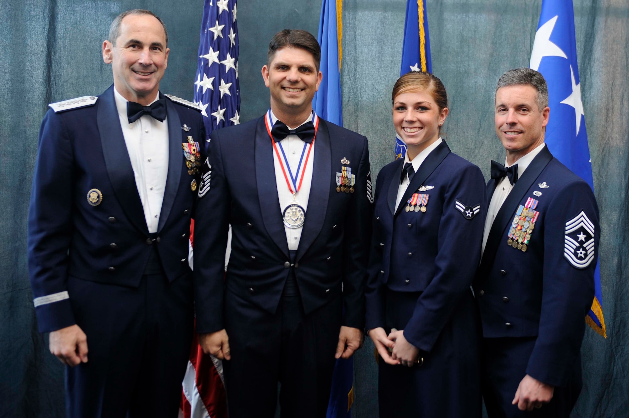 Gen. Raymond E. Johns, Air Mobility Command commander, is pictured with Master Sgt. Joseph Kazimer, 421st Combat Training Squadron, Joint Base McGuire-Dix-Lakehurst, Airman 1st Class Nicole Kazimer, 39th Airlift Squadron, Dyess Air Force Base, Texas and AMC Command Chief Master Sgt. David Spector at the AMC annual awards banquet April 8th at Scott AFB, Ill. (Photo by Senior Airman Wesley Farnsworth).