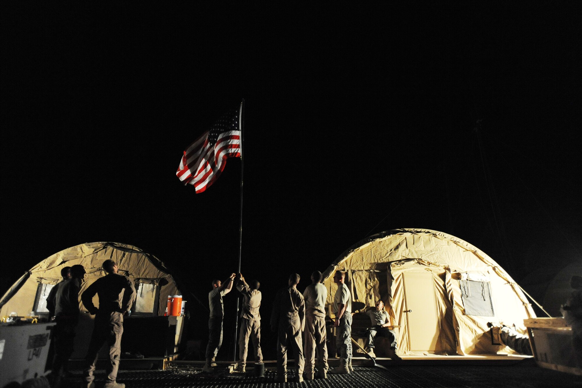Members of the 79th Expeditionary Rescue Squadron secure the unit's flag to a pole, April 10, 2010, at Camp Bastion, Afghanistan. With the first alert mission complete, Airmen in the squadron look forward to a successful deployment, while showing off the unique capabilities of the HC-130P “Combat King” aircraft. (U.S. Air Force photo/Staff Sgt. Manuel J. Martinez/released)
