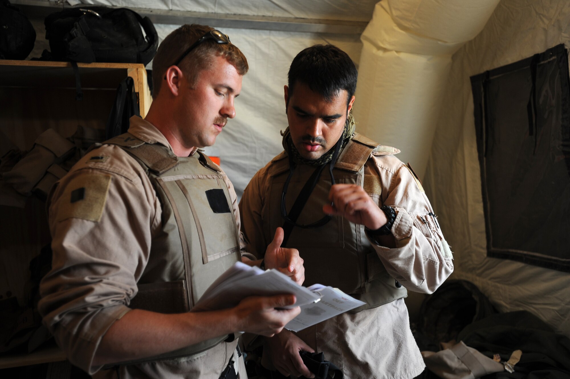 First Lieutenant John Grahm, an HC-130P “Combat King” Hercules pilot and Senior Airman Jorge Jimenez, an HC-130P airborne mission systems specialist, both deployed to the 79th Expeditionary Rescue Squadron, go over flight information April 10, 2010, at Camp Bastion, Afghanistan. (U.S. Air Force photo/Staff Sgt. Manuel J. Martinez/released)