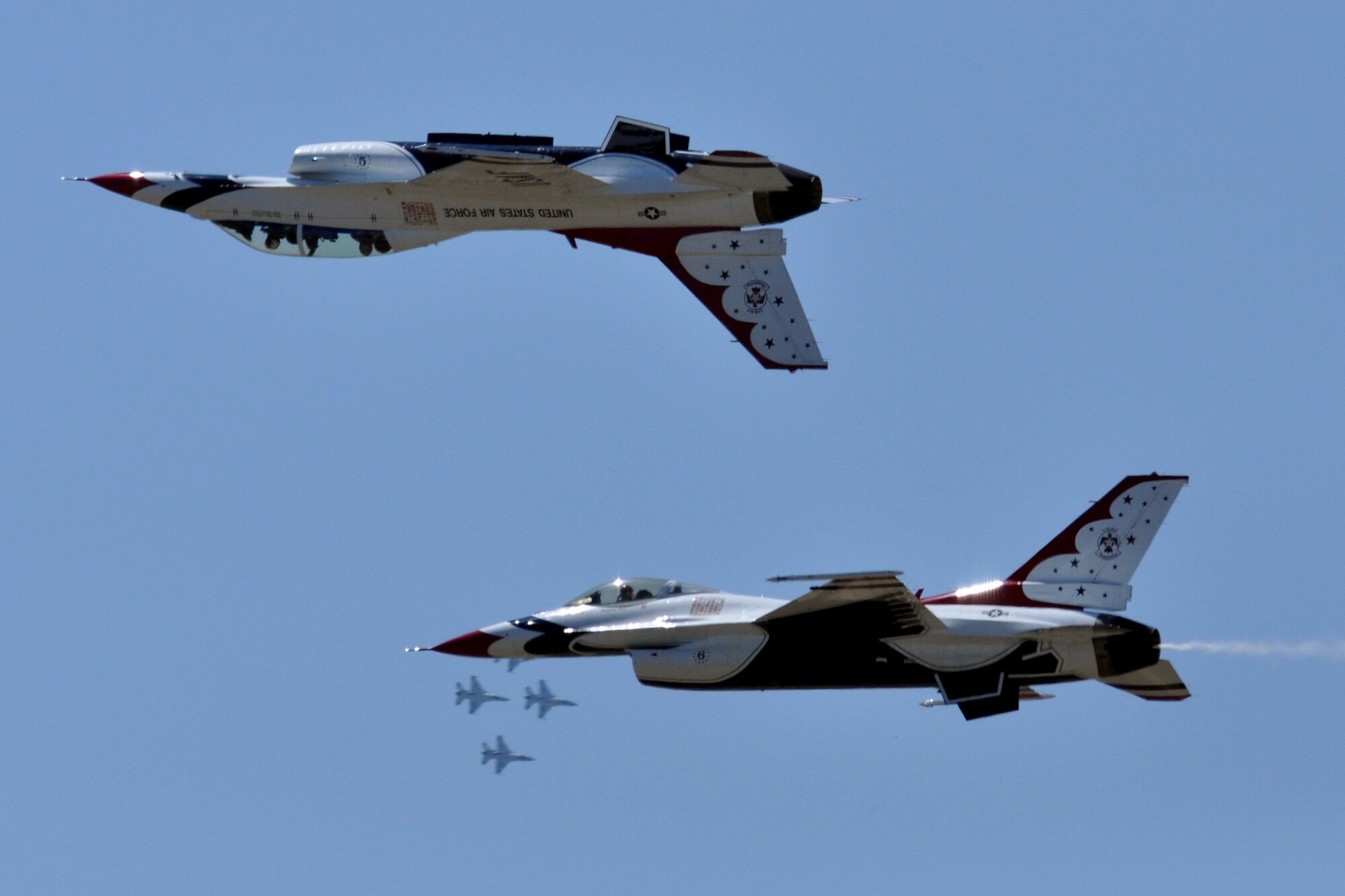 EGLIN AIR FORCE BASE, Fla. -- Two of the Air Force Thunderbirds F-16s perform an inverted pass while three others come around for another pass during the practice show April 9 here.  The weekend airshow drew more than 70,000 people each day.  The T-birds headlined the show. (U.S. Air Force photo/ Airman 1st Class Anthony Jennings)