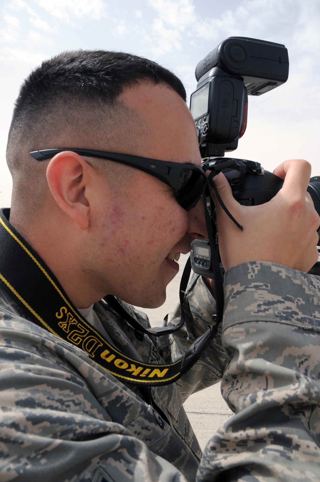 Staff Sgt. Leonel Gallardo takes photos during an event on the flightline for the 380th Air Expeditionary Wing at a non-disclosed base in Southwest Asia on March 1, 2010.  Sergeant Gallardo is the knowledge operations manager for the 380th Expeditionary Maintenance Group. He is deployed from the 18th Civil Engineer Group at Kadena Air Base, Japan, and his hometown is Phoenix, Ariz.  (U.S. Air Force Photo/Master Sgt. Scott T. Sturkol/Released)