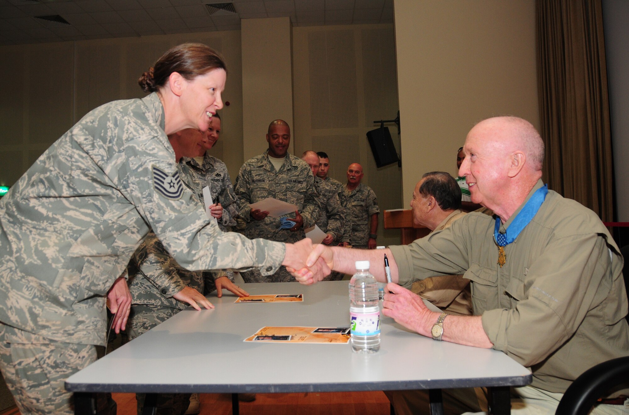 U.S. Air Force Tech. Sgt. Gina Porter, 386th Expeditionary Civil Engineer Squadron, shakes hands with Medal of Honor recipient Don Jenkins April 10, 2010 at an air base in Southwest Asia. Mr. Jenkins and fellow Medal of Honor recipient Retired Lt. Col. Alfred Rascon shared their Vietnam experiences and words of wisdom with Airmen as part of a tour through the U.S. Central Command area of responsibility. (U.S. Air Force photo by Staff Sgt. Lakisha A. Croley/Released)