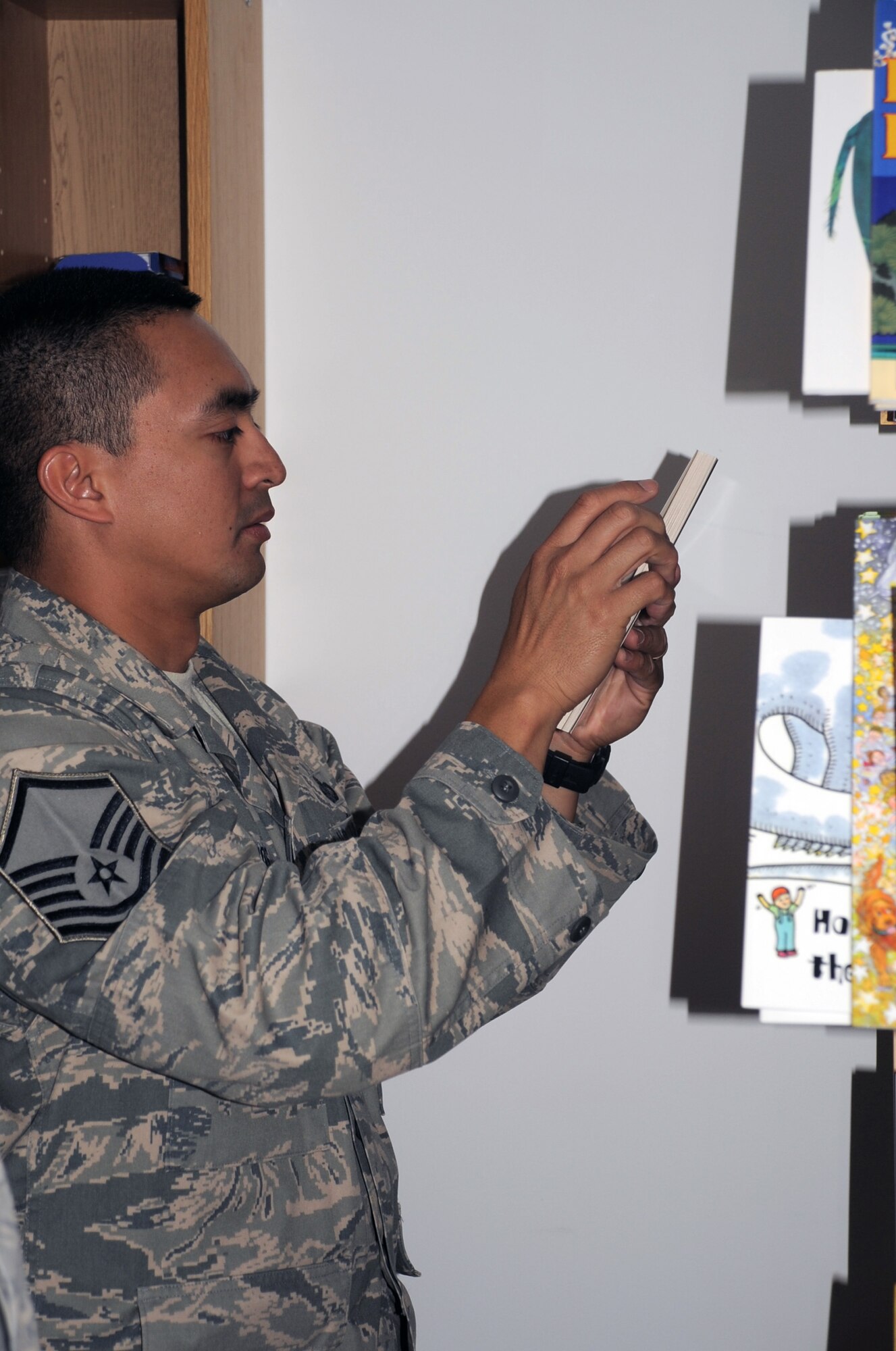 Master Sgt. Greg Ramos, services superintendent with the 380th Expeditionary Force Support Squadron, looks for a book for to read his children April 8, 2010, at a non-disclosed base in Southwest Asia. Sergeant Ramos was the second Airman at the 380th Air Expeditionary Wing to participate in the United Services Organization's United Through Reading program. The program allows for a deployed service member to read a book while being recorded and the book and a DVD is sent home to a child to see and follow along. Sergeant Ramos is deployed from the 154th Force Support Squadron at Hickam Air Force Base, Hawaii, and his hometown is Kapolei, Hawaii. (U.S. Air Force Photo/Master Sgt. Scott T. Sturkol/Released)