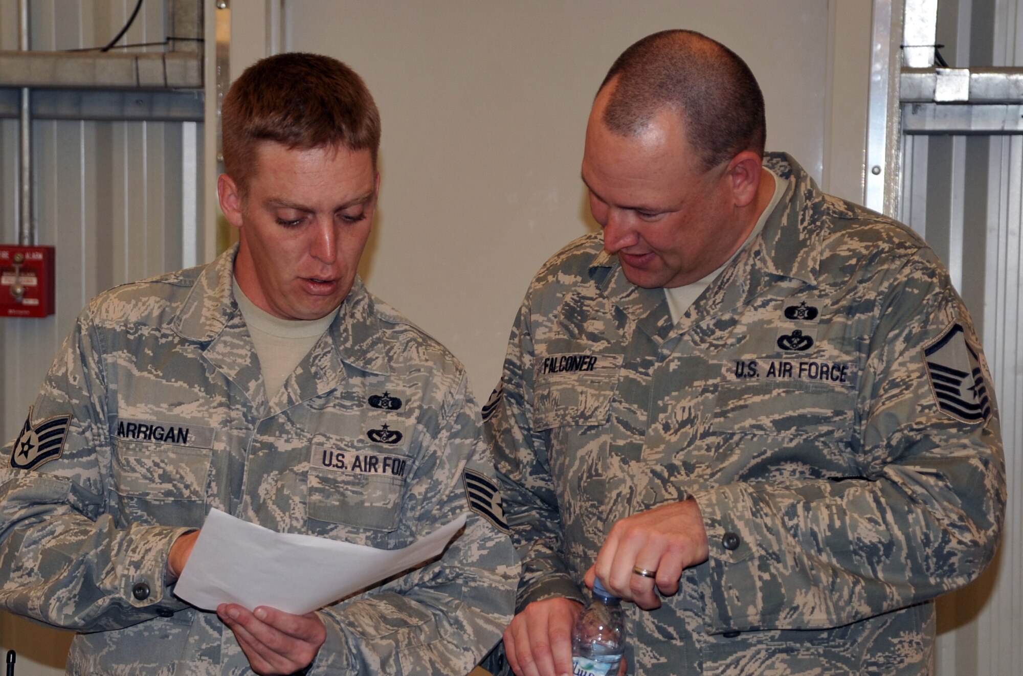 Staff Sgt.Brian Garrigan, emergency management craftsman with the 380th Expeditionary Civil Engineer Squadron emergency management flight, talks with Master Sgt. Brian Falconer, flight superintendent, while participating in a co-agency training exercise with the 380th Expeditionary Medical Group bioenvironmental engineering section April 9, 2010, at a non-disclosed base in Southwest Asia. The exercise helped maintain readiness and cooperation between agencies for events such as a hazardous material response. Sergeants Falconer and Garrigan are deployed from the 4th Civil Engineer Squadron at Seymour-Johnson Air Force Base, N.C. (U.S. Air Force Photo/Master Sgt. Scott T. Sturkol/Released)
