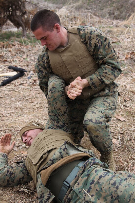Lance Cpl. Michael Banks, a Combat Logistics Company 36 welder, executes a counter to the mount on Cpl. Robert Giuliani, chemical, biological, radiological and nuclear defense specialist and training noncommissioned officer with CLC-36, during a test for his green belt in the Marine Corps Martial Arts Program here April 12.