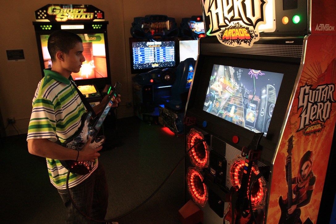 Gregory McAlexander takes a break from shopping to play a round of Guitar Hero at the arcade located inside the Marine Corps Exchange April 13. The arcade features 16 games of various types and play.