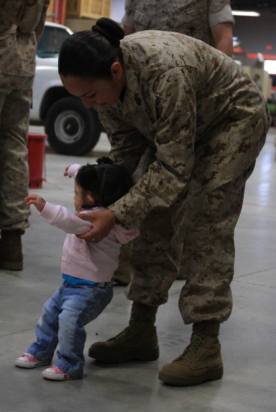 MARINE CORPS AIR GROUND COMBAT CENTER TWENTYNINE PALMS, Calif. - Sgt. Teresa Diaz, a wireman with the data element of Marine Unmanned Aerial Vehicle Squadron 1, helps her 1-year-old daughter, Giselle, walk before departing for a seven-month deployment to Afghanistan April 13.