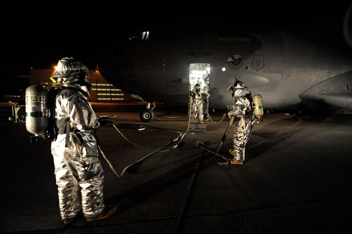 Firefighters advance a water line through a C-17 to ensure they do not become hung up, while assisting the attack crew inside the aircraft April 12, 2010, at Joint Base Charleston, S.C. Firefighters from the 628th Civil Engineer Squadron, Fire Emergency Services Flight, practice C-17 egress training to ensure they know how to respond to aircraft mishaps. (U.S. Air Force photo by James M. Bowman/released)