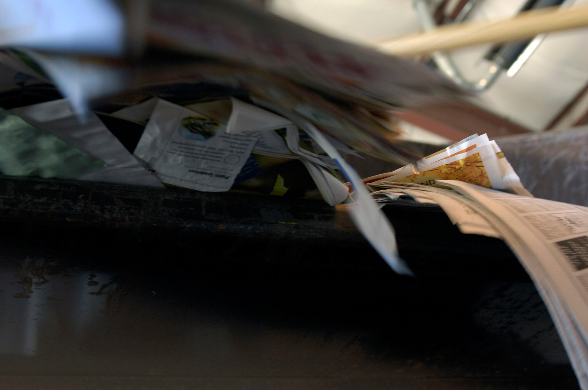 Recyclable newspaper is dumped into a bailing machine April 12, 2010, to bail it for storage and sale. Recyclable materials are separated and bailed according to the type of material. (U.S. Air Force photo/Staff Sgt. Jason Barebo) 
