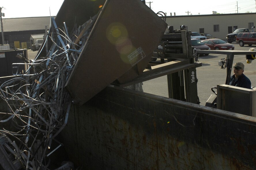 Mr. Mark Davis, Whiteman Recycling Center material examiner, transfers recyclable scrap metal to a bin containing more scrap metal April 12, 2010. Revenue from the recycling center has funded many base projects including the rubberized coating on the running track and the batting cages. (U.S. Air Force photo/Staff Sgt. Jason Barebo)