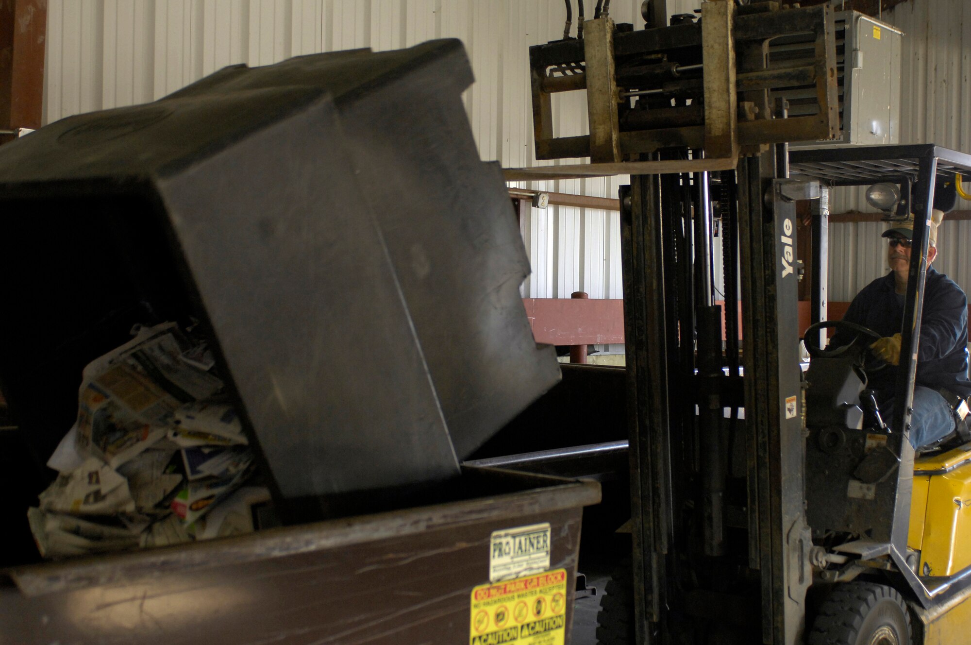 Mr. Mark Davis, Whiteman Recycling Center material examiner, transfers recyclable newspaper to a bin containing more newspaper April 12, 2010. The recycling center personnel store recyclable material until enough is collected to be bailed. (U.S. Air Force photo/Staff Sgt. Jason Barebo)
