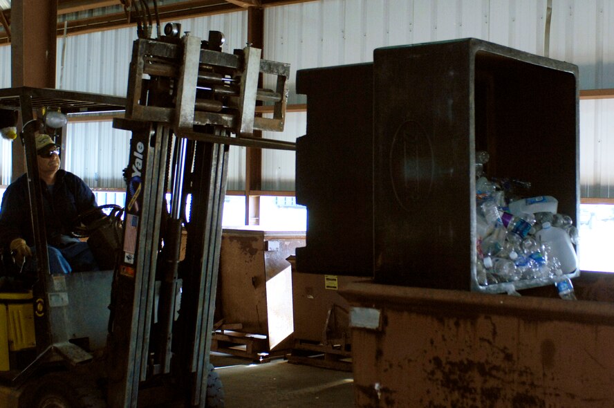 Mr. Mark Davis, Whiteman Recycling Center material examiner, transfers recyclable plastic to a bin containing more plastic April 12, 2010. The recycling center personnel store recyclable material until enough is collected to be bailed. (U.S. Air Force photo/Staff Sgt. Jason Barebo)