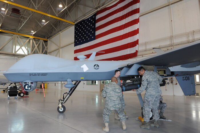 CREECH AIR FORCE BASE, Nev. -- Senior Airman Valerio Mendoza, and Senior Airman Domingo Morales, weapons loaders assigned to 432nd Aircraft Maintenance Squadron, load an inert AGM-114 Hellfire II air-to-ground missile to a MQ-9 Reaper, April 12, 2010, during the 432d AMXS load crew of the quarter competition. (U.S. Air Force Photo by Airman 1st Class Brett Clashman)
