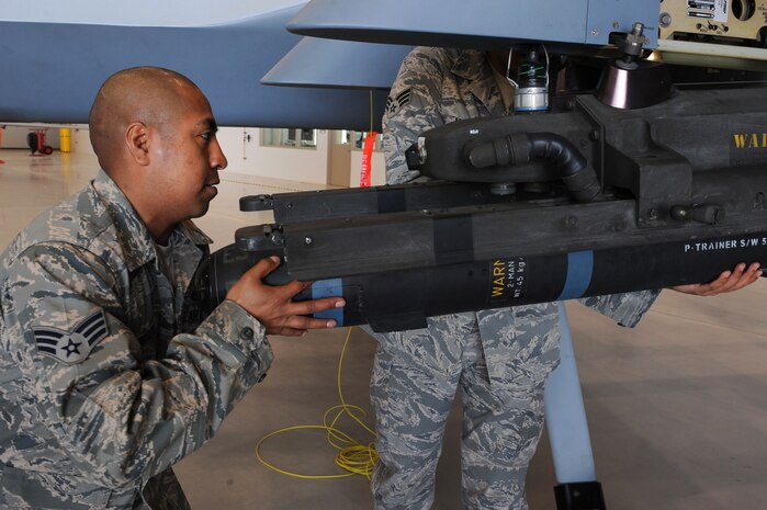 CREECH AIR FORCE BASE, Nev. -- Senior Airman Valerio Mendoza, weapons loader assigned to 432d Aircraft Maintenance squadron, loads an inert AGM-114 Hellfire II air-to-ground missile to a MQ-9 Reaper, April 12, 2010, during the 432d AMXS load crew of the quarter competition. (U.S. Air Force Photo by Airman 1st Class Brett Clashman)
